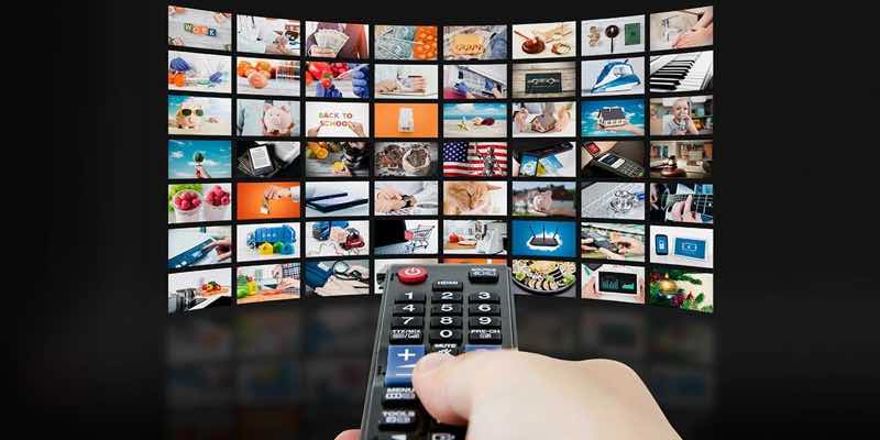 grid of television shows with a hand holding a remote control