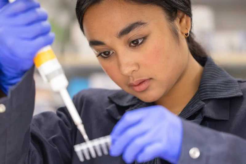woman in a research lab works on a device