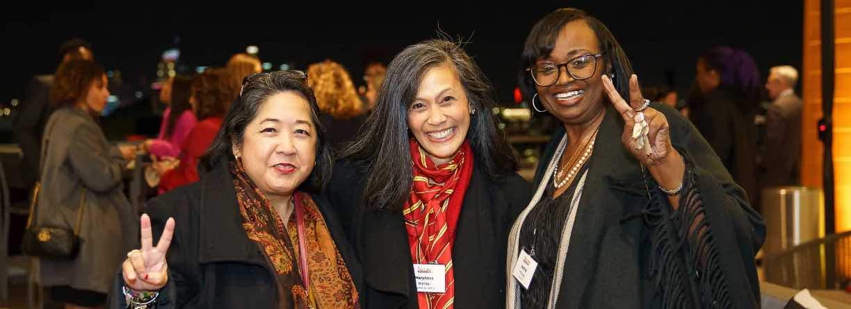 women stand close together at an alumni event