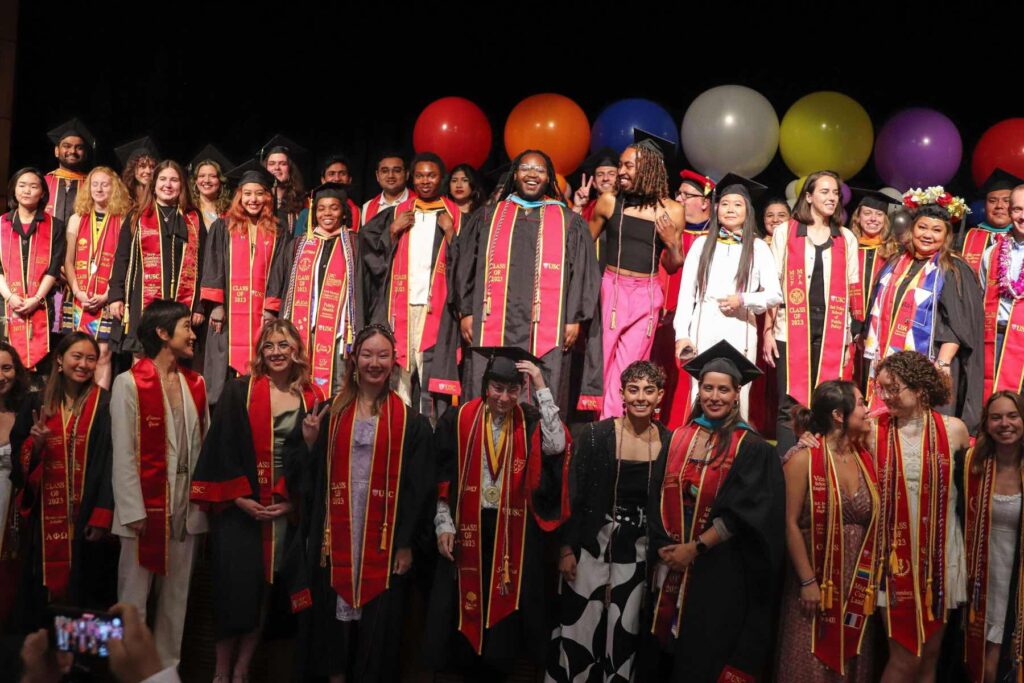 USC grads celebrate on risers at a graduation ceremony