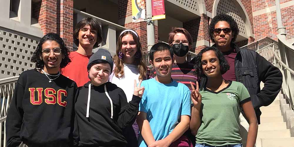 group of students pose on the stairs by the LGBTQ+ student center