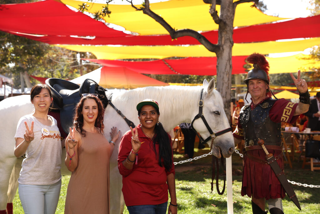 three women pose with Traveler the horse