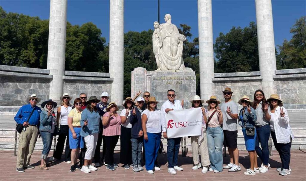 group stands in front of statue