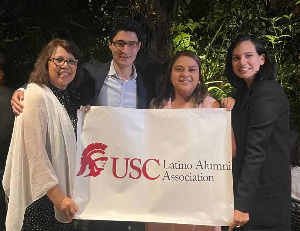 Latino Alumni Association group holding a banner