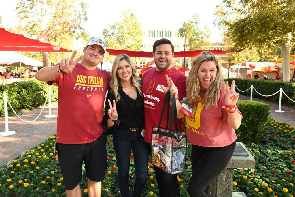 four alumni pose for a photo at a reunion