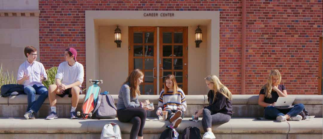 students sit on benches outside the Career Center