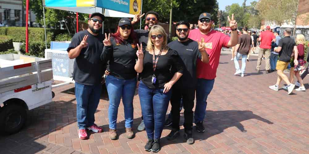 a group of six people poses on campus